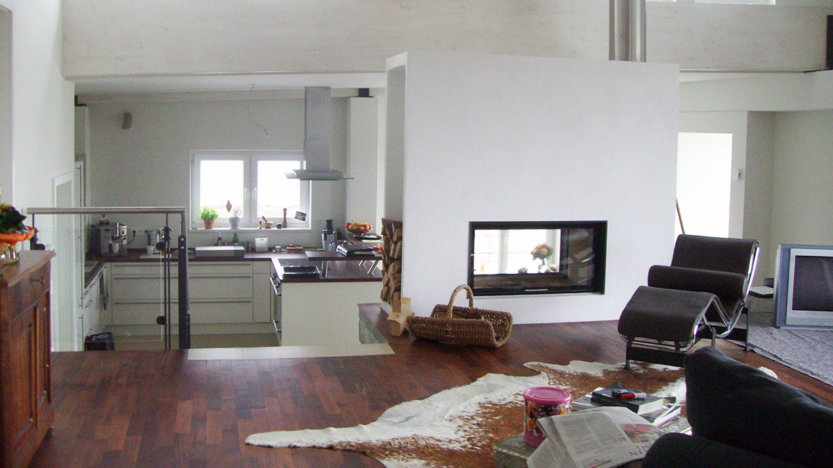 Wohnzimmer und Küche mit Kamin in der Wohnung über der Werkstatt